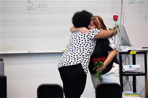 Deidre Deal receives a rose from a former student